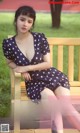 a woman sitting on top of a wooden bench