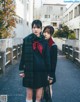 A couple of young women standing next to each other on a street.