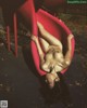 A naked woman laying on a red slide.