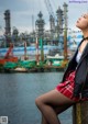 A woman sitting on a wall next to a body of water.