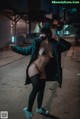 A woman dressed as a cat holding a flashlight in her hand.