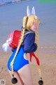 A woman in a bunny costume standing on a beach.