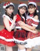 A group of three young women dressed in santa claus outfits.