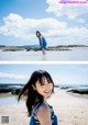 A woman standing in the water on a beach.