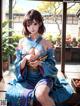 A woman in a blue kimono sitting on a window sill.