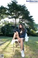 A woman sitting on top of a chair in a park.